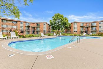 A pool surrounded by apartment buildings with a no swimming sign on the ground.